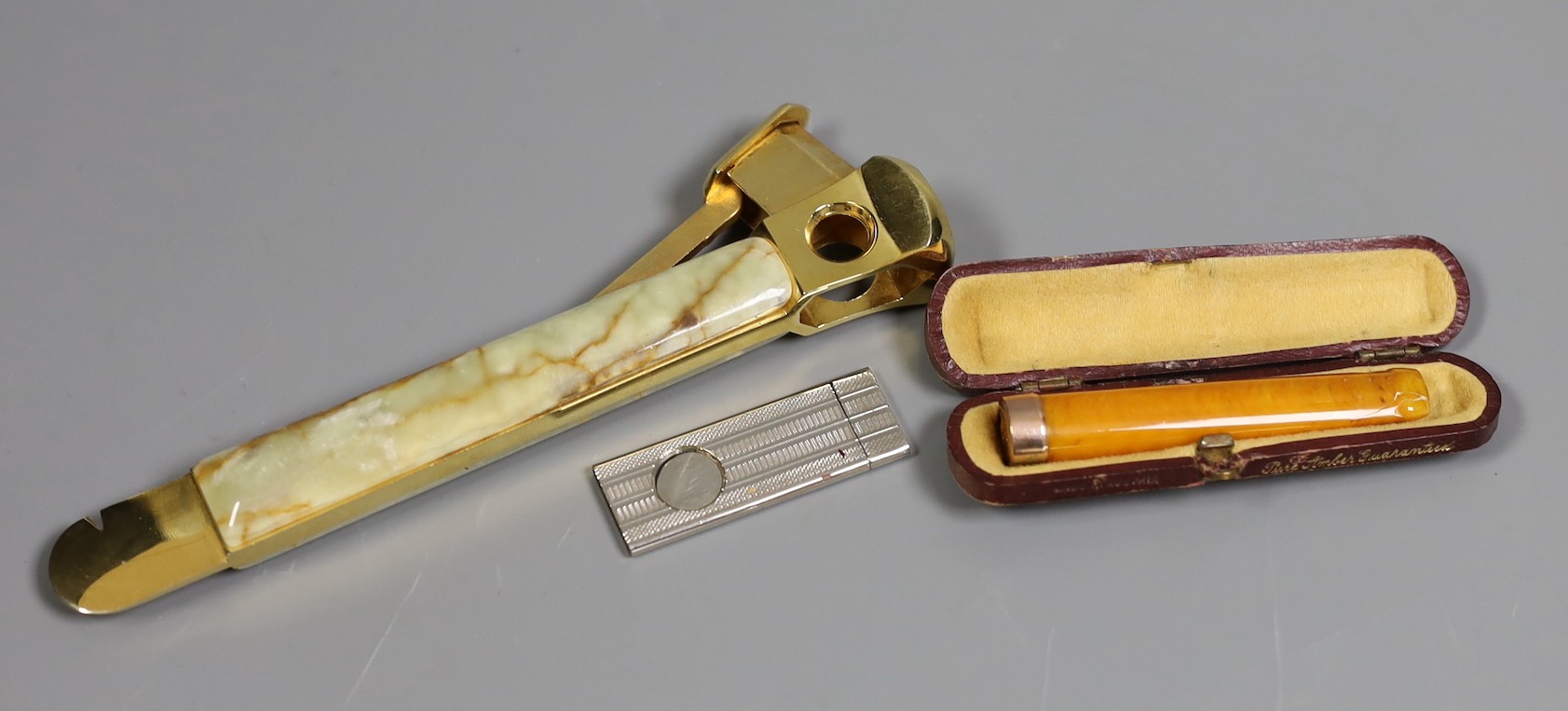 An onyx and gilt-metal cigar cutter, a smaller plated cheroot cutter and a cased 9ct mounted cheroot holder